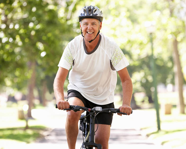 Homme dans la cinquantaine faisant du vélo dans un parc